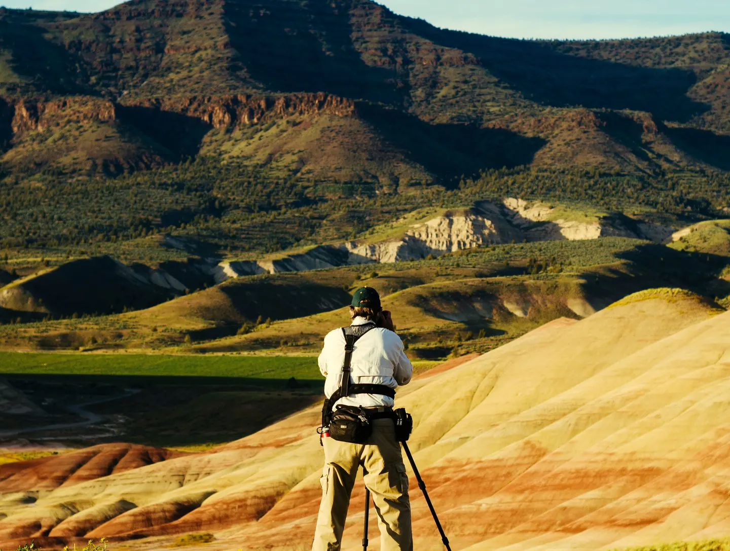 Person seen from behind facing layered hills.